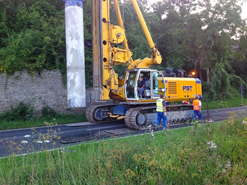 Bohrgerät arbeitet auf Asphalt, geschützt durch robuste Kunststoffplatten.