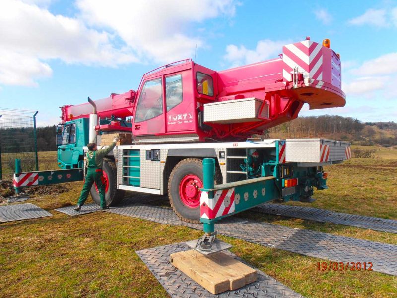 Mobilkran auf stabiler Stellfläche aus Bodenschutzplatten für sicheres Arbeiten auf unebenem Gelände.