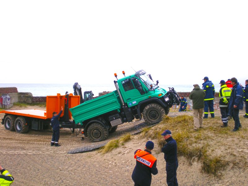 Einsatzfahrzeug überwindet sandige Rampe auf Bodenschutzplatten.