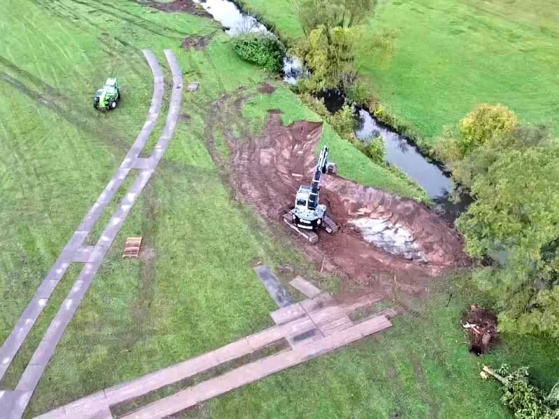 Langlebige Fahrplatten als mobile Baustraße schützen Waldboden & Wiesen bei Bauarbeiten zur Renaturierung eines Flussbetts.