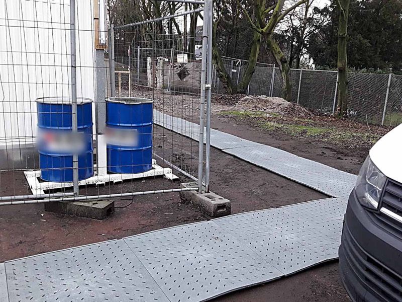 Vor einem Raumcontainer wurde ein Gehweg aus Bodenmatten verlegt