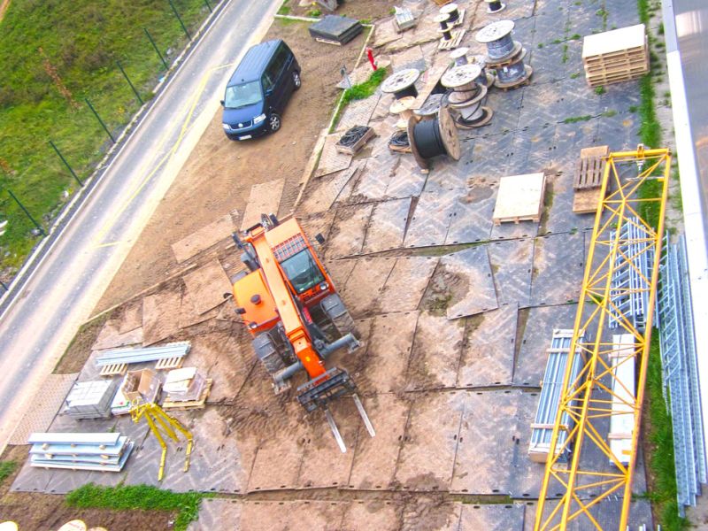 Große Arbeitsplattform als BE-Fläche mit Baumaschinen und Kabeltrommeln auf stabiler Fläche