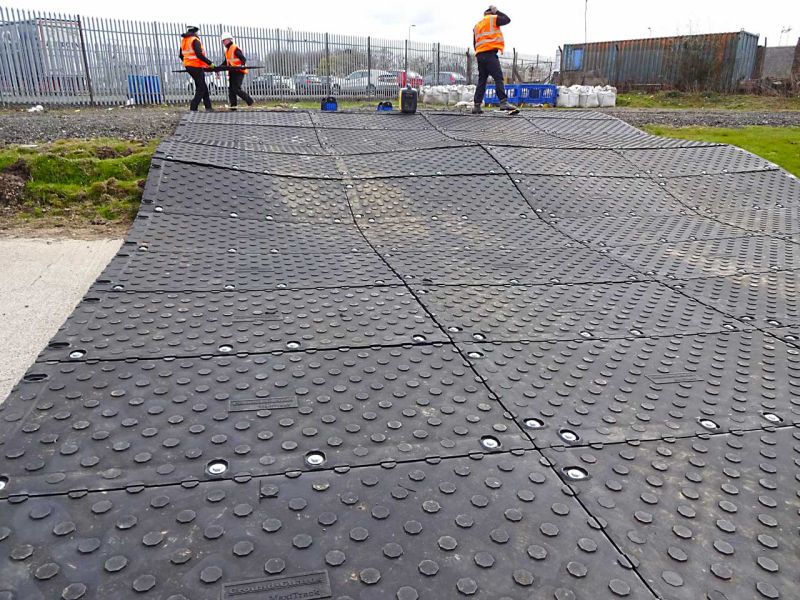 Eine mobile Baustraße aus Fahrplatten, die auf einer unwegsamen Wiese geschaffen wurde
