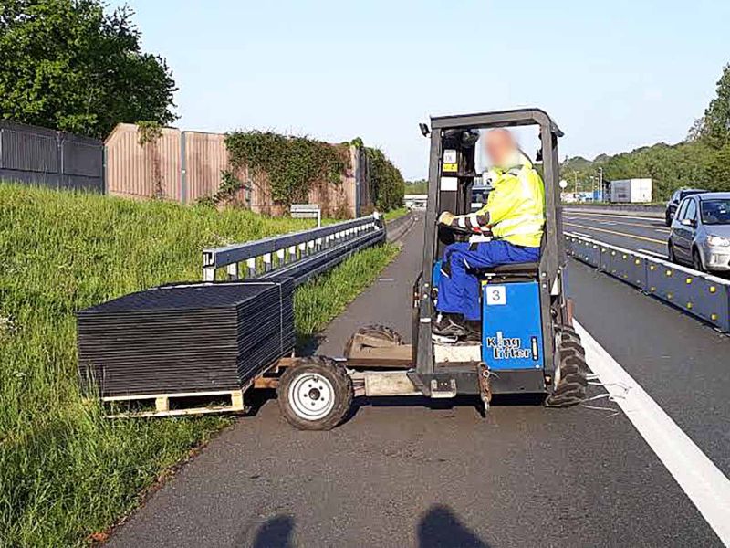 Ein Stapler mit einer Palette Bodenschutzplatten steht auf dem Seitenstreifen