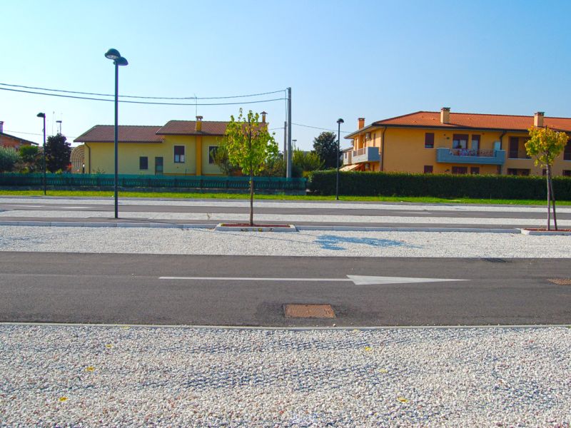 Übersicht über einen neu angelegten Kiesparkplatz mit stabilisierter, wasserdurchlässiger Oberfläche.