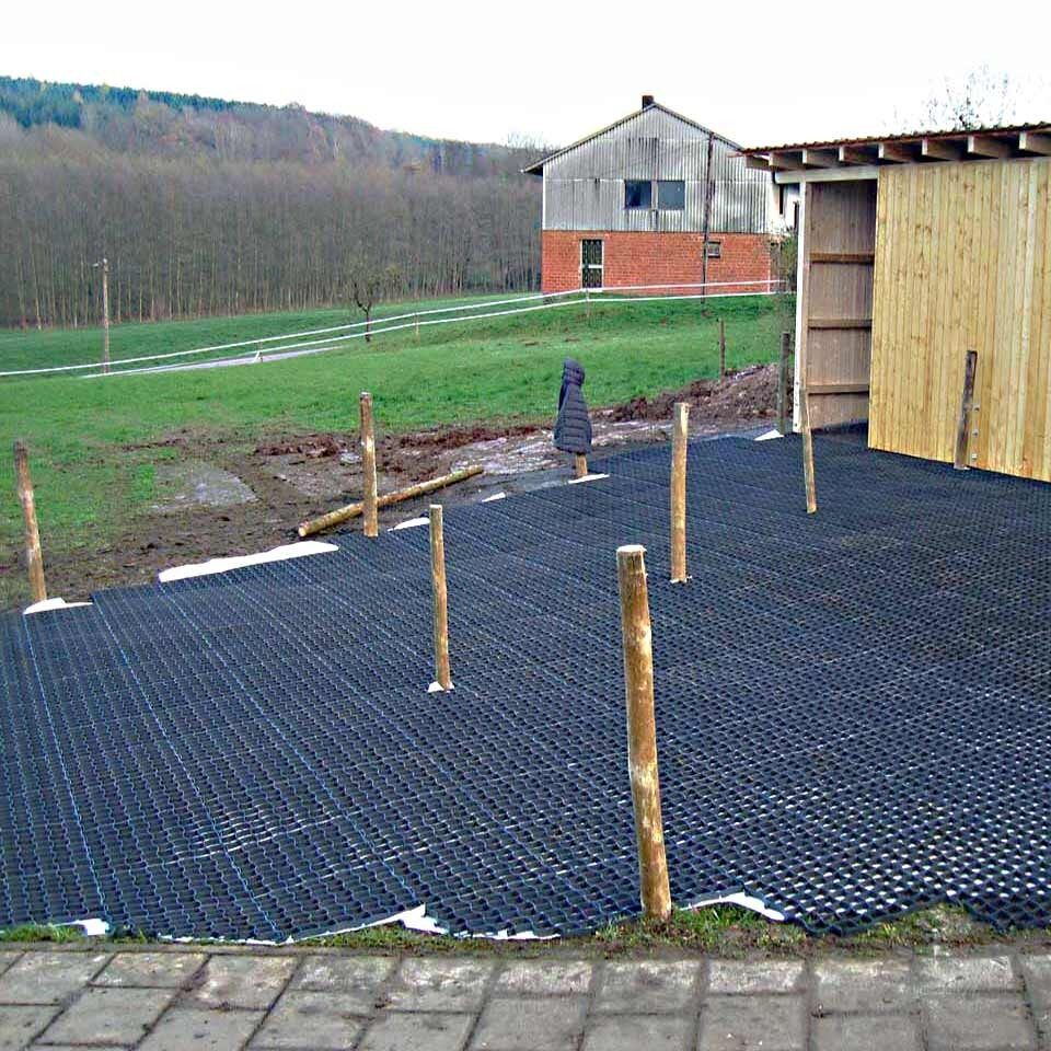 Neu verlegte Bodengitter BG30/BG50 auf einer Rasenfläche neben einem Schuppen aus Holz