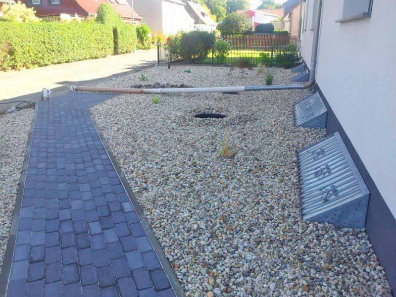 Moderne Umgestaltung: Steingarten & Carporteinfahrt mit stabilisiertem Kies