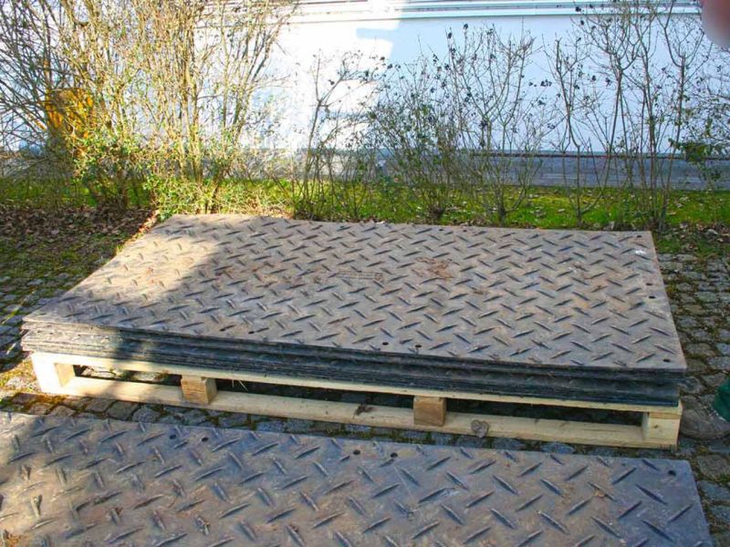 Gestapelte s:tek-Bodenschutzplatten auf einer Holzpalette, bereit zur Verlegung.