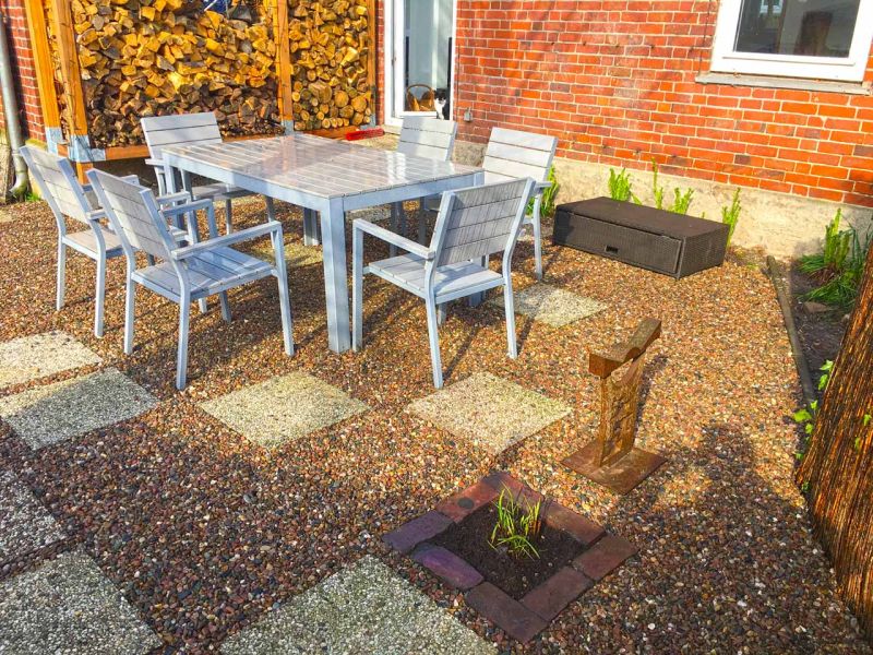 Schön gestalteter Steingarten mit einer Kiesfläche als Terrasse