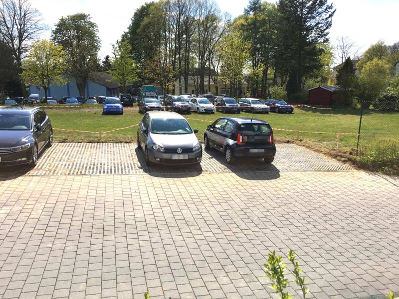 Fahrzeuge auf Parkplatz aus Kunststoff-Rasengittersteinen