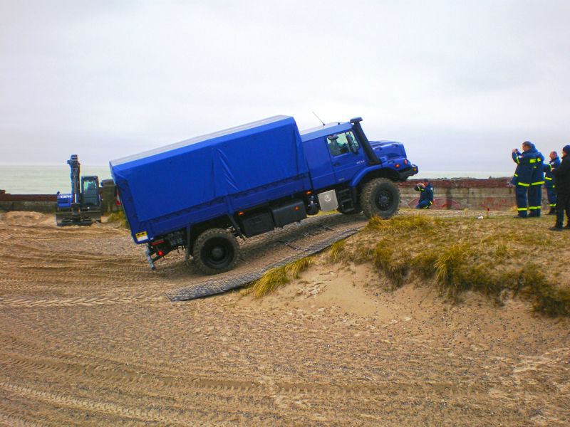 Lkw fährt über sandige Kuppe dank ausgelegter Bodenschutzplatten.