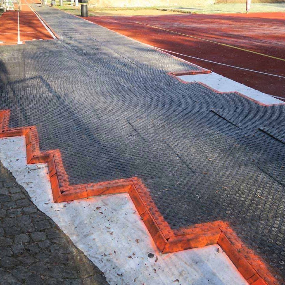 Bodenmatte als Abdecksystem zum Schutz einer Tartanbahn vor dem Baustellenverkehr