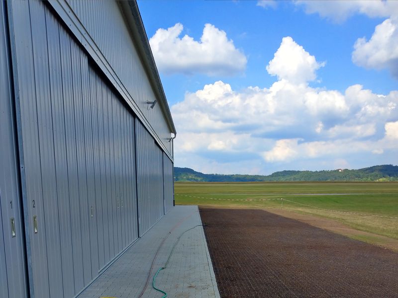 Immer auf der Höhe – Bodengitter BG50 zur Befestigung zweier Rasenflächen vor einer Flugzeughalle