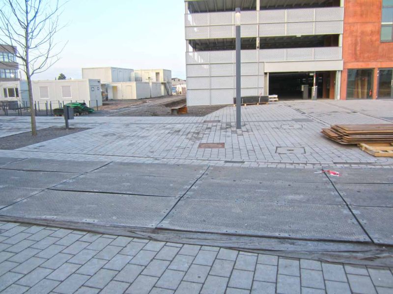Eine s:tek Hochleistungs-Bodenschutzplatte liegt auf einer Baustelle und schützt den Boden vor schweren Fahrzeugen.