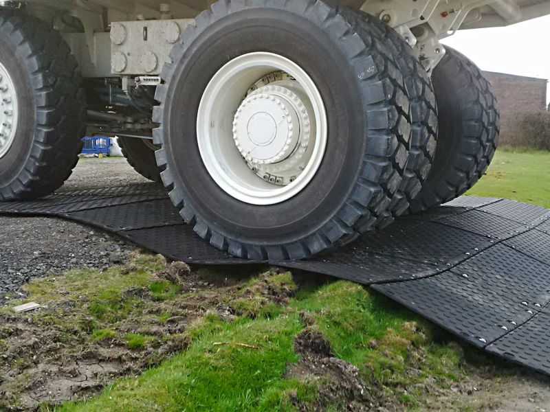 Der Muldenkipper fährt über die MaxiTrack-Schwerlastfahrplatte. Der Boden unter der Platte ist uneben.