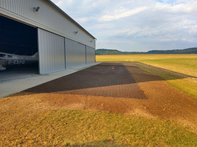 Immer auf der Höhe – Bodengitter BG50 zur Befestigung zweier Rasenflächen vor einer Flugzeughalle