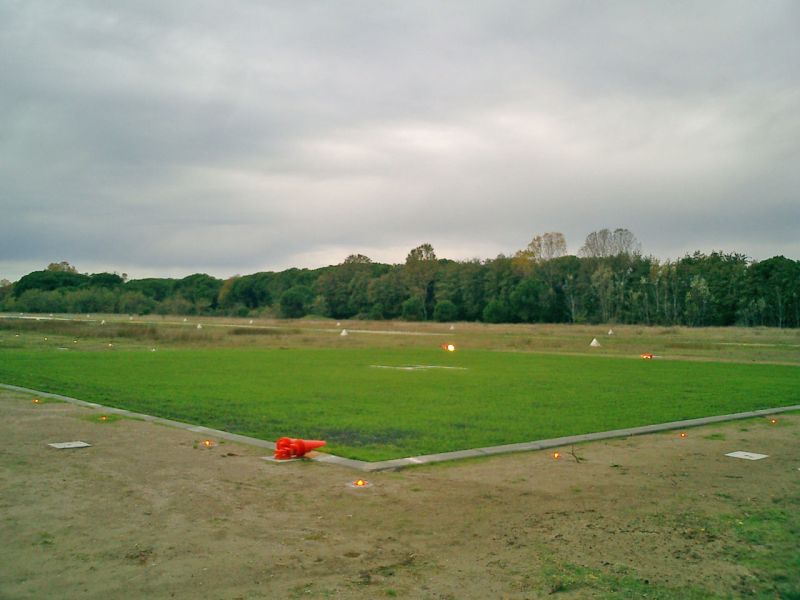 Große begrünte Helikopterlandefläche in naturnaher Umgebung.