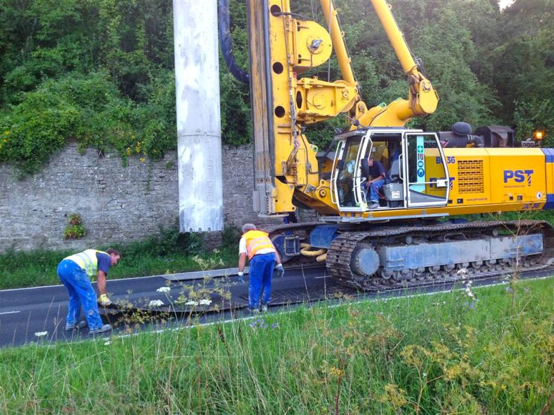 Mitarbeiter setzen mobile Schutzplatten vor einem Bohrgerät um.