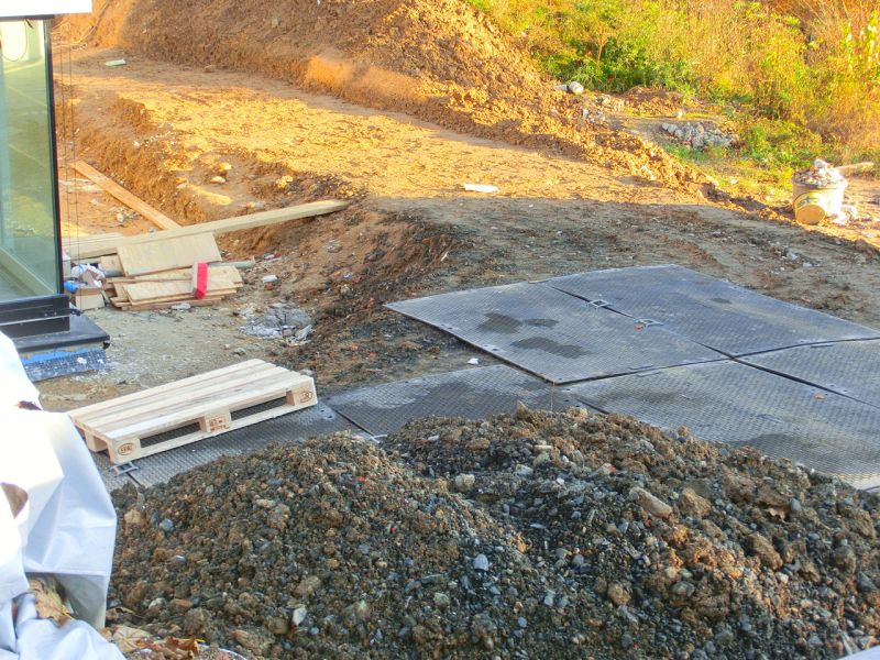 Bodenschutzplatten stabilisieren das unbefestigte Gelände auf der Baustelle eines Einfamilienhaus.