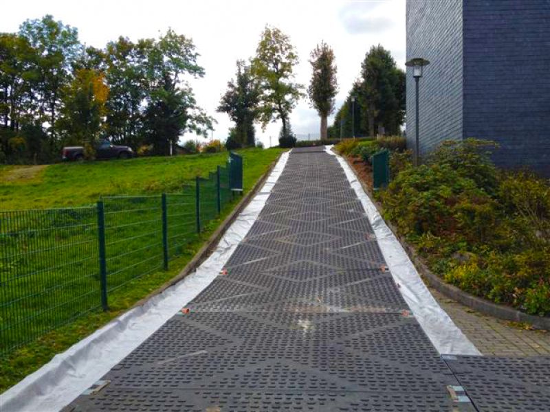 Komplett ausgelegte Kunststoffplatten sichern eine steile Zufahrtsrampe und schaffen eine stabile Fahrstrecke für den Mobilkran.