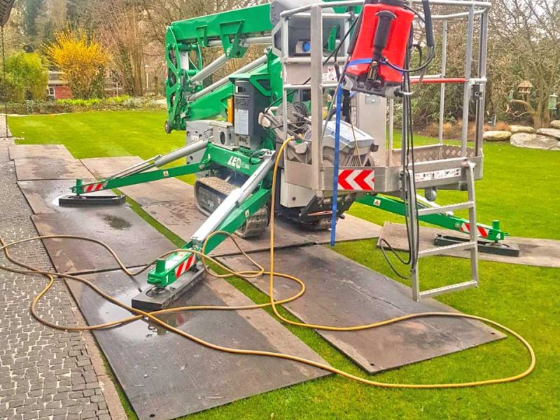 Kompakte Raupenarbeitsbühne auf v:tek Fahrplattenplatten zum Schutz empfindlicher Grünflächen