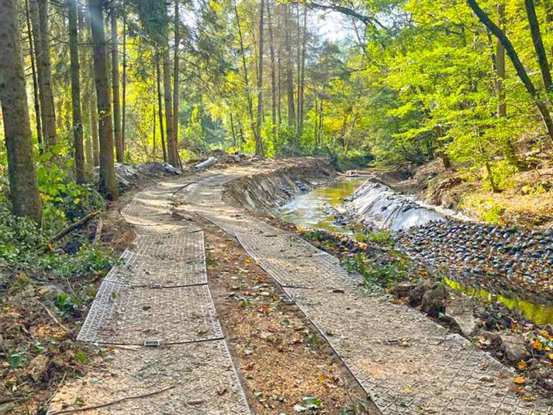 Fahrplatten zum Schutz des Waldboden während Baumfällungen am Bachlauf