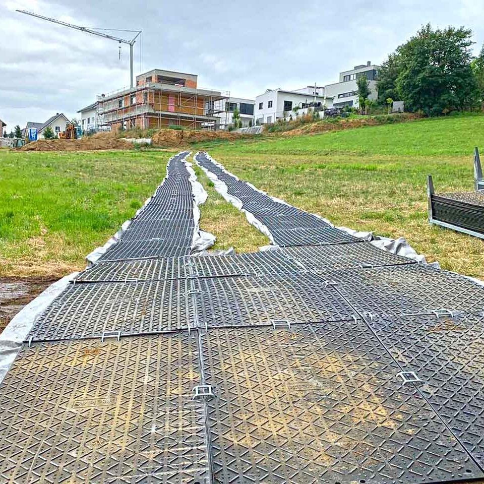 x:tek Fahrplatten aus Kunststoff mit beidseitiger Profilierung als Baustraße zum Bodenschutz und Flächenschutz und Pflasterschutz auf Baustellen.