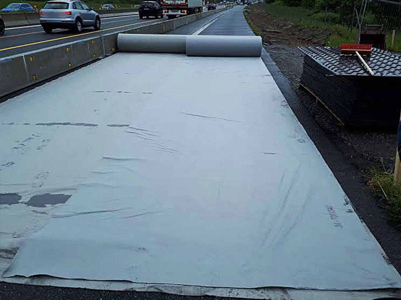 Trennvlies wurde auf Asphalt ausgebreitet, damit ein temporärer Pannenstreifen darauf verlegt werden kann.