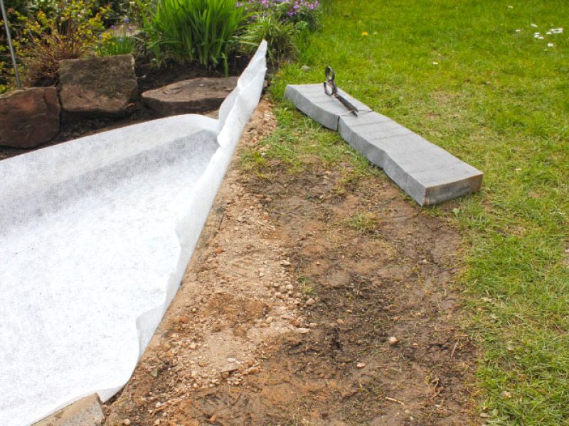 Verlegen von Kieswaben KW50 für einen stabilisierten Kiesweg im Garten
