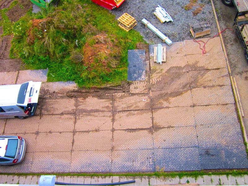 Temporäre Arbeitsplattform als BE-Fläche mit Fahrzeugen und Bodenschutzplatten im Einsatz