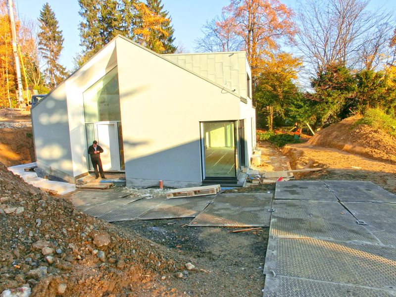 Baustelle mit moderner Architektur und verlegten Fahrplatten zur sicheren Zufahrt beim Bau eines Einfamilienhaus.