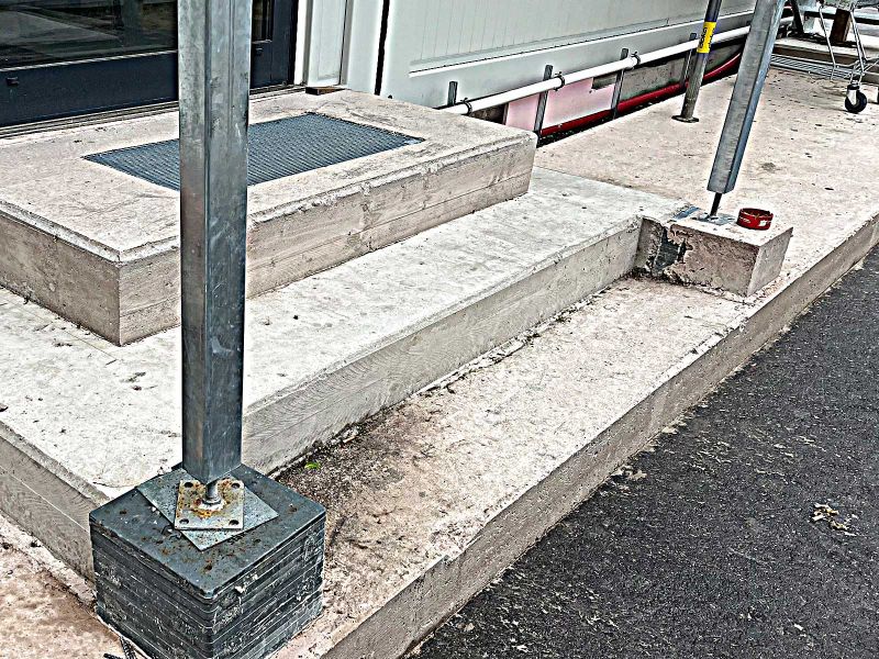 Ein Treppengestell wird mit Unterlegplatten abgestützt.