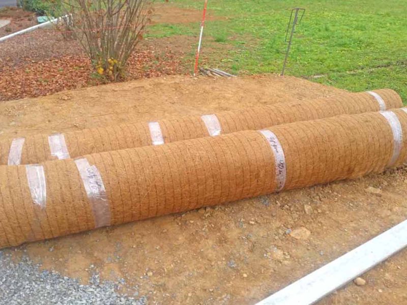 Zwei aufgerollte Kokosmatten für die Böschungsbefestigung und Erosionsschutz.