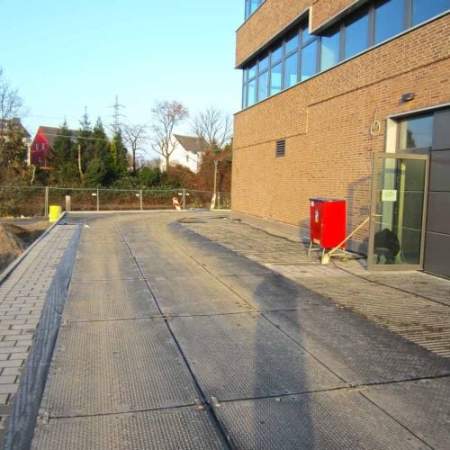 s:tek Bodenschutzplatten schützen das Pflaster auf einer Baustelle. Sie verteilen die Last von Baufahrzeugen gleichmäßig.
