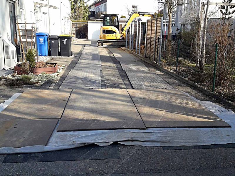 Baustelleneinrichtung mit e:tek PRO Fahrplatten und Gummimatten als Pflasterschutz in einer Hofeinfahrt
