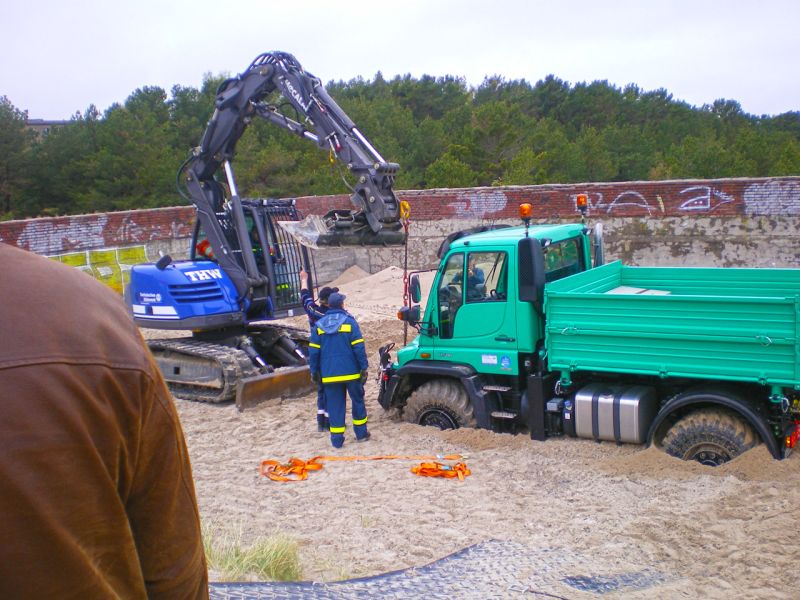 Mehrere Fahrzeuge werden aus tiefem Sand geborgen.