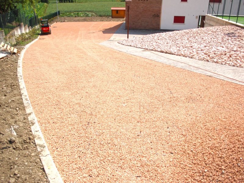 Fertige Kieszufahrt mit rötlichem Material in Gitterstruktur.