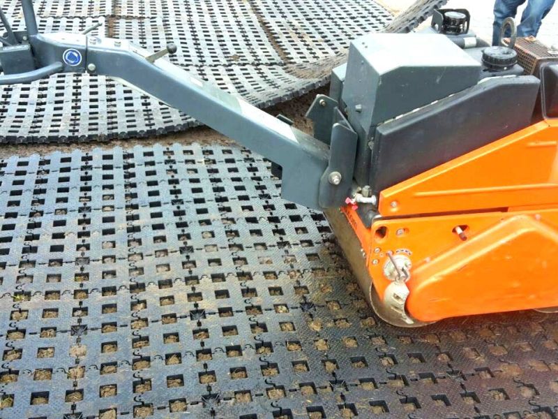 Kleine Walze fährt auf Kunststoff-Rasengittersteinen