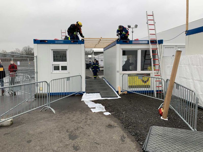 Verlegung von Bodenmatten durch das THW Marburg um den barrierefreien Gehweg zum Impfzelt des Covid Impfzentrum des LK Marburg-Biedenkopf herzustellen.