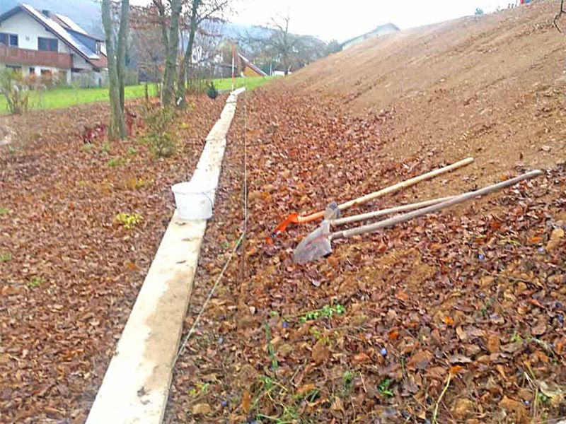 Hangbefestigung in Arbeit, mit Schaufeln und Werkzeugen auf dem Boden.