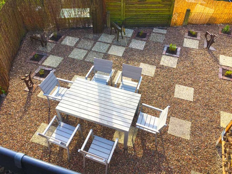 Umwandlung eines drögen Hinterhofes in einen schön gestalteten Steingarten mit einer Kiesfläche als Terrasse