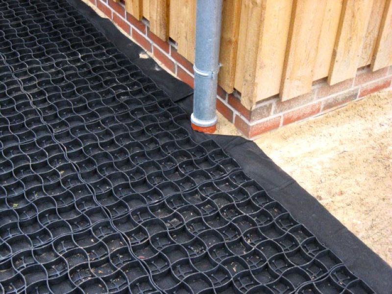 Ein Bodengitter wurde exakt zugeschnitten, um sich an eine Regenrinne und die Hauswand anzupassen.