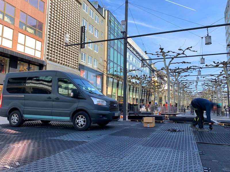 Ein Fahrzeug fährt über eine Fläche aus xtek46 Fahrplatten, die in einer Fußgängerzone verlegt wurden.