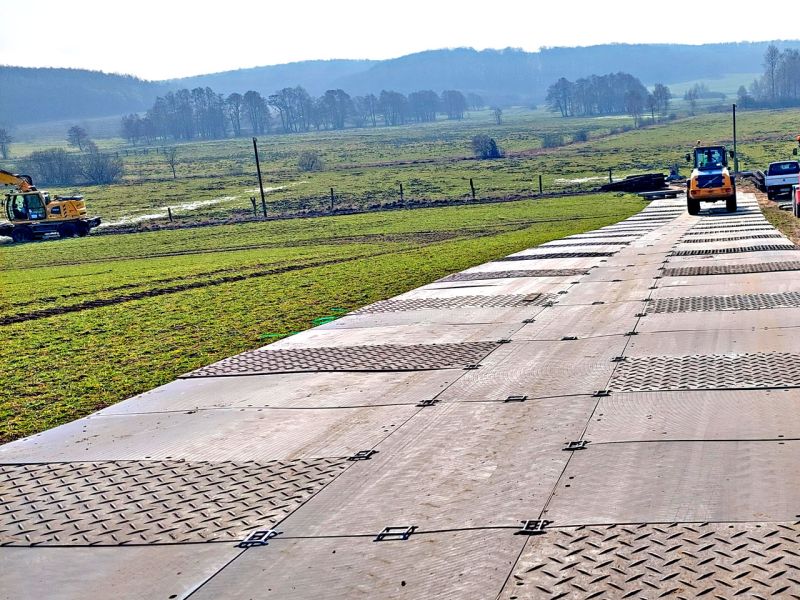 Fahrplatten wurden auf einer Wiese verlegt, um eine mobile Baustraße zu schaffen