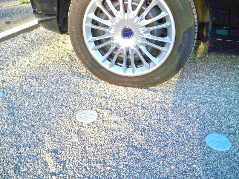 Autoreifen auf stabiler Kiesparkfläche mit Parkplatzmarkierung