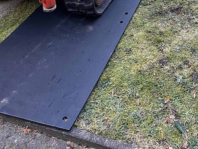 Eine Fahrplatte liegt auf dem Rasen. Der Randstein ist ebenfalls von der Platte abgedeckt