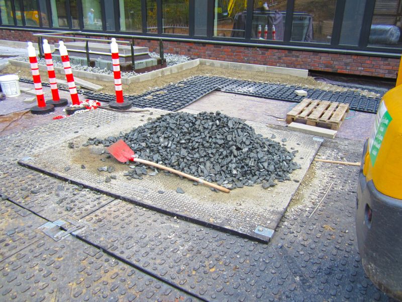 Schotterhaufen und Werkzeuge auf geschützter Dachfläche während Begrünung