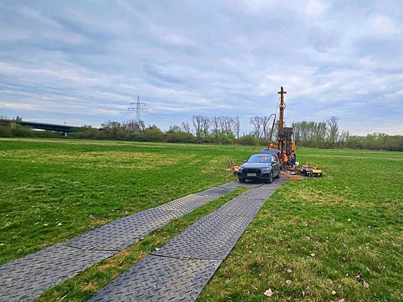 Mobile Baustraße aus Bodenschutzplatten führt zu einer Bohrstelle im offenen Gelände