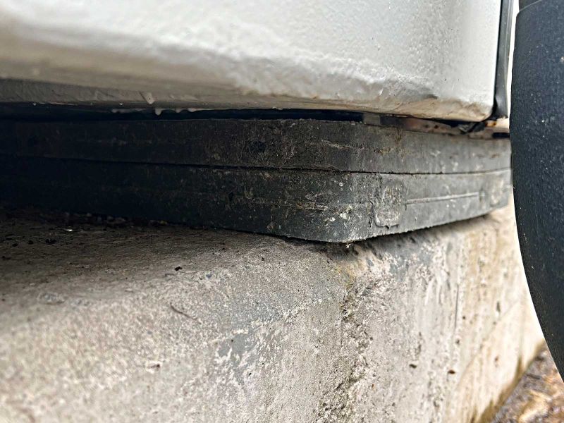 Nivellierplatte als Unterlage für einen weißen Container zum Höhenausgleich und zur Unterpallung. Zwei Platten wurden gestapelt.