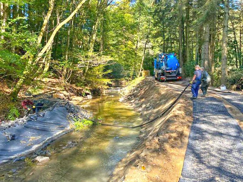 Fahrplatten zum Schutz des Waldboden während Baumfällungen am Bachlauf
